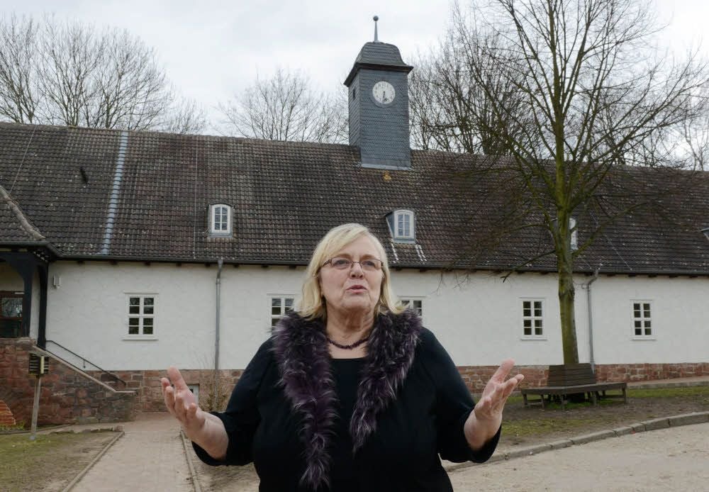 Barbara Depping vor dem Grundschulgebäude, wo sie selbst zur Schule ging und heute Schulleiterin ist