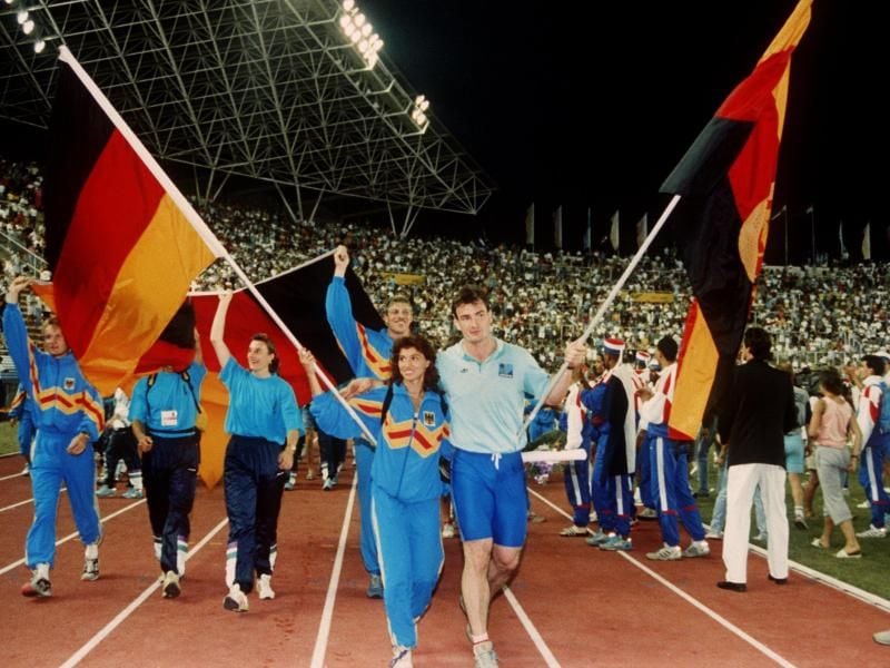 Arm in Arm: Fahnenträger Gabriele Lippe aus der Bundesrepublik und Ulf Timmermann aus der DDR 1990 bei der Schlußfeier der Leichtathletik-EM im jugoslawischen Split. Foto: -/dpa