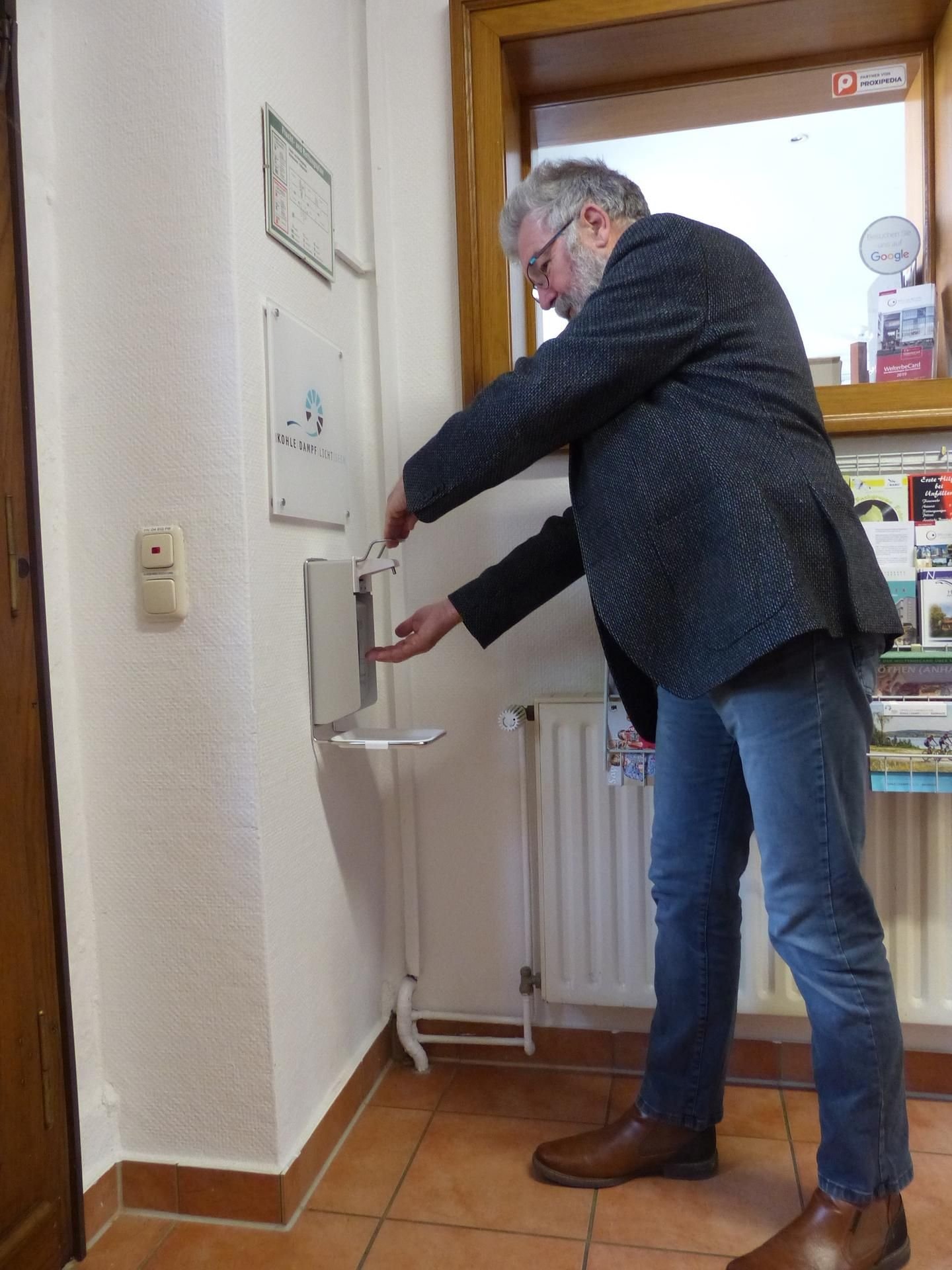 Uwe Holz testet den Spender für Desinfektionsmittel.