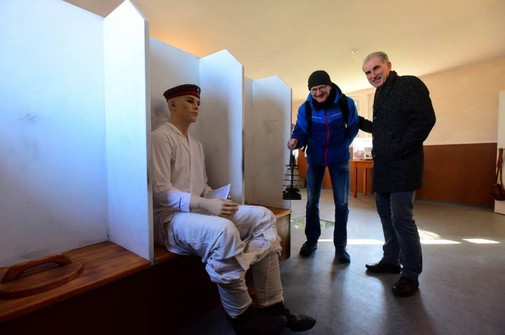 Mike Sachse (links) und Jens Fischer am Nachbau der Latrinen im Ausstellungsraum des historischen Gebäudes.