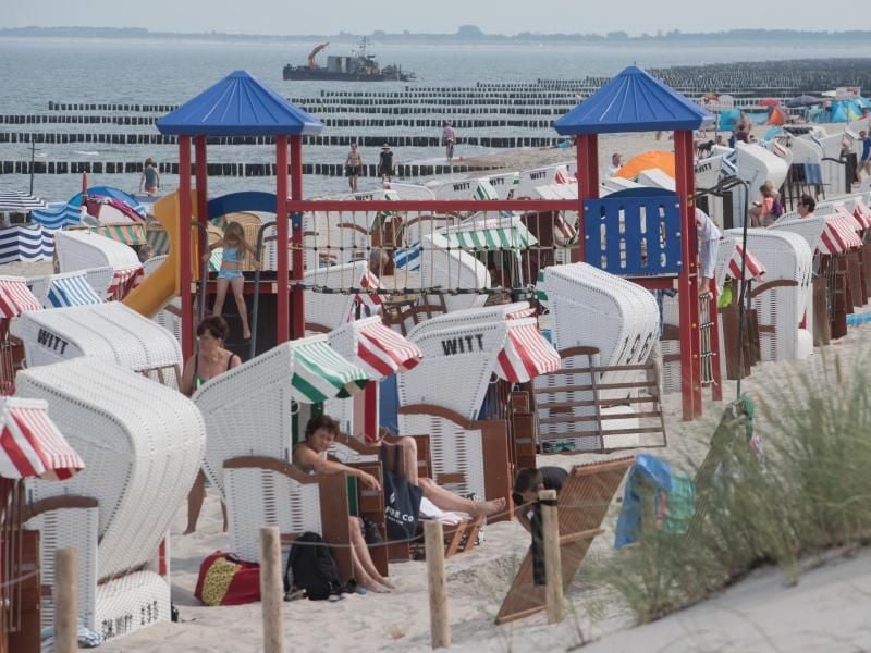 Am Ostseestrand vor der Seebrücke haben sich Badegäste niedergelassen. Foto: Stefan Sauer/dpa-Zentralbild/ZB/archiv