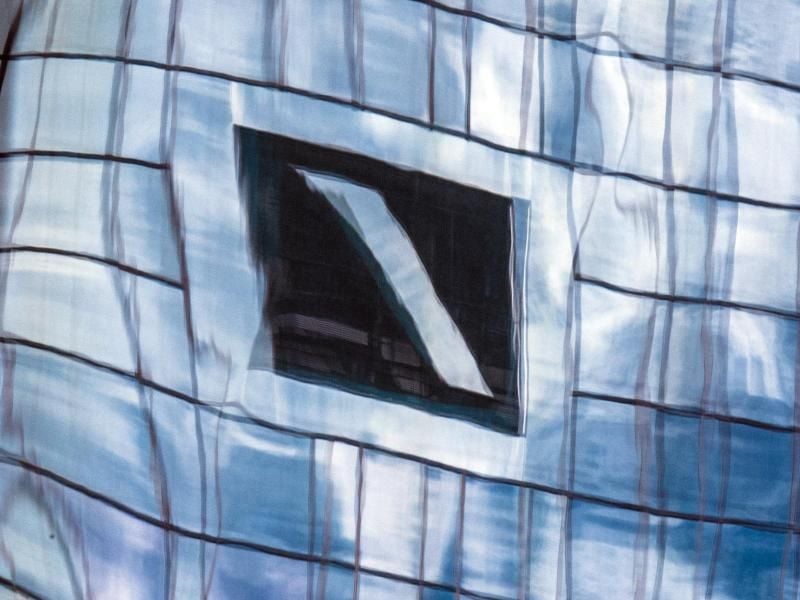 Die Zentrale der Deutschen Bank spiegelt sich in einer Glasfassade. Foto: Boris Roessler/dpa