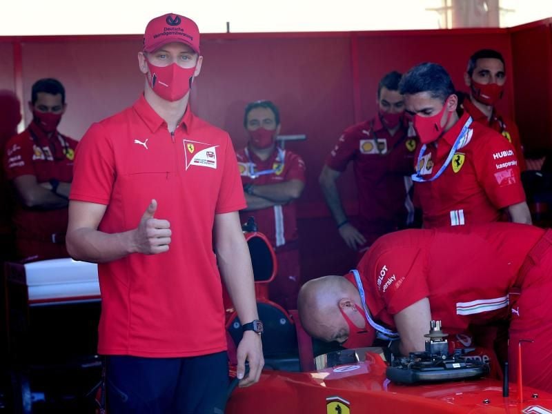Mick Schumacher (l) besucht die Box von Ferrari. Foto: Jennifer Lorenzini/Pool Reuters/AP/dpa