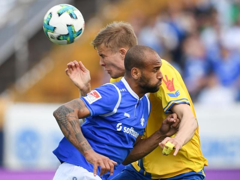 Darmstadts Terrence Boyd (vorn) und Braunschweigs Frederik Tingager versuchen an den Ball zu kommen. Foto: Arne Dedert