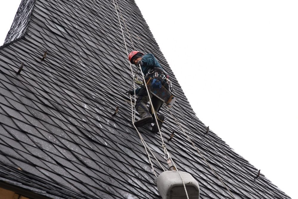 Maik Jänicke hat sich am Nordturm der Jakobskirche zur beschädigten Schieferfläche abgeseilt.
