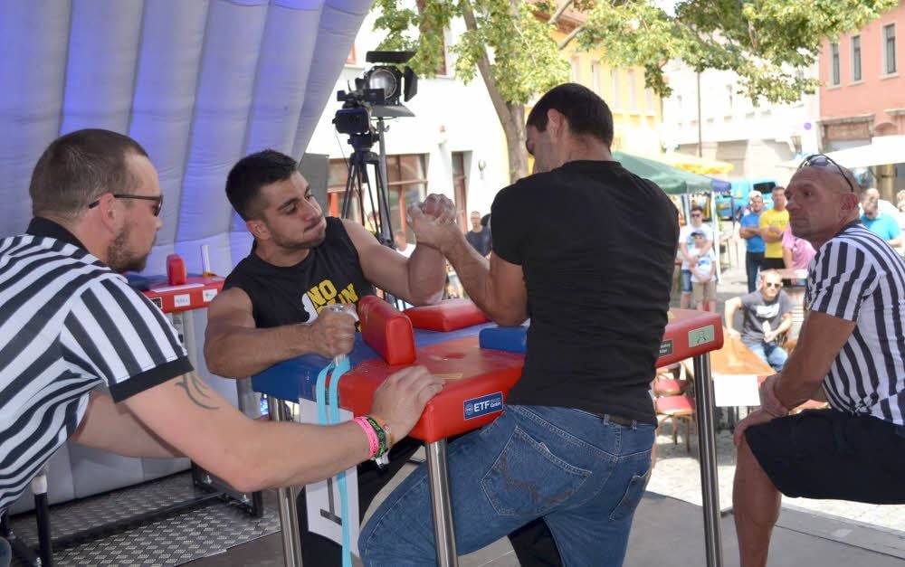 Die Schiedsrichter Marko Lüpke und Michael Muche (in gestreiften T-Shirts) beobachten die Armwrestler ganz genau.