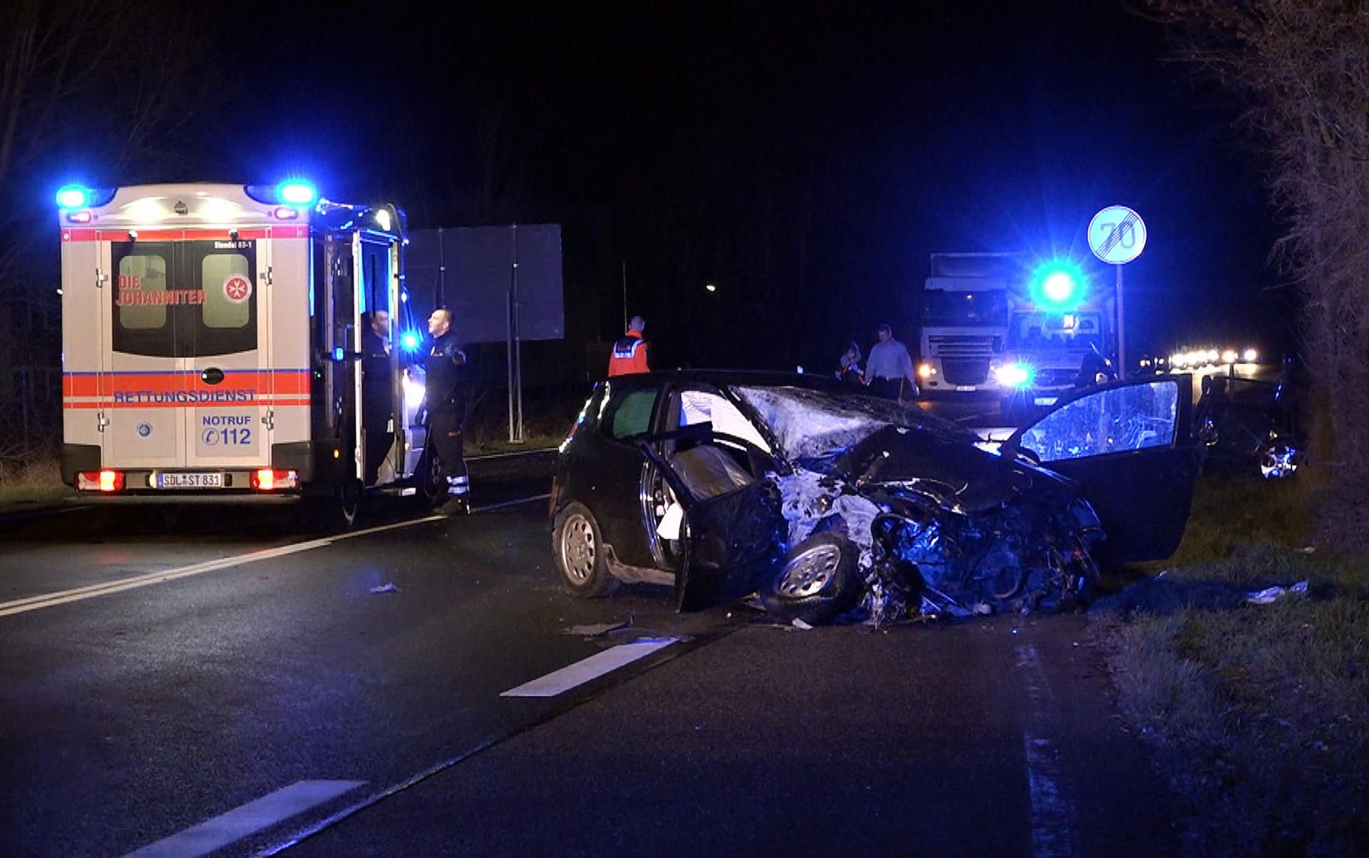 Ein Rettungswagen ist an einer Unfallstelle auf der Bundesstraße 189 bei Osterburg (Sachsen-Anhalt) neben einem zerstörten Auto zu sehen.