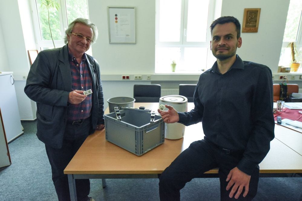 Wassereimer, Behälter mit Luftfeuchtemesser und Luftbefeuchter - so hat sich die Mol Katalysatortechnik an das Corona- Thema herangearbeitet. Jürgen Koppe (l.), und Jens Linck (2. Geschäftsführer) zeigen beide noch einen Sauberwürfel, der nach ihrer Meinung den Unterschied macht.