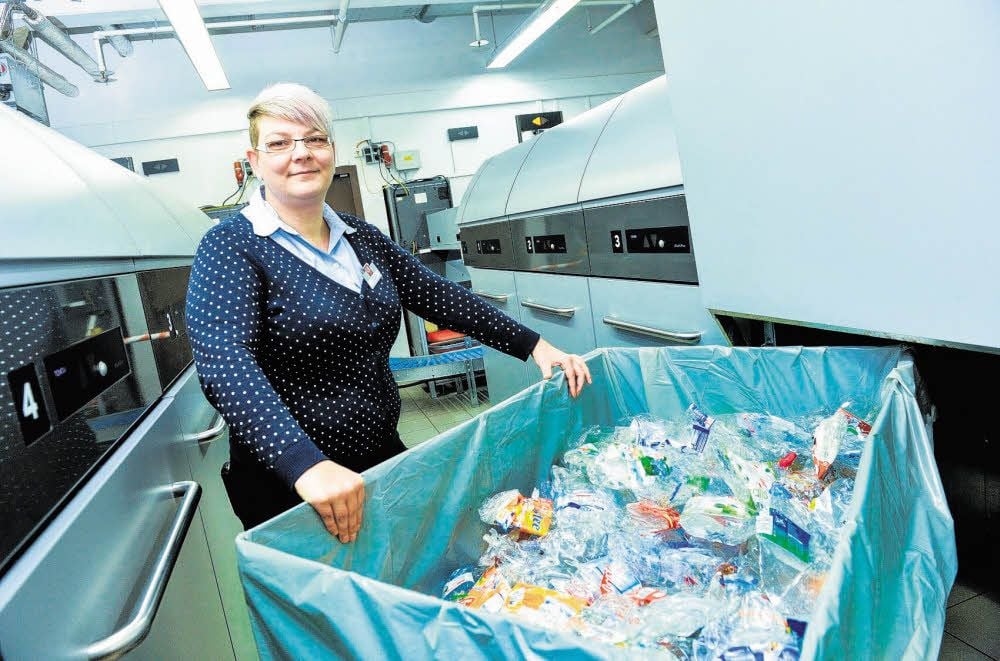 Peggy Lips zeigt, wie PET-Flaschen aussehen, die im Kompaktor landen. Der Automat drückt Flasche für Flasche zusammen. Die Säcke müssen mehrmals am Tag geleert werden.