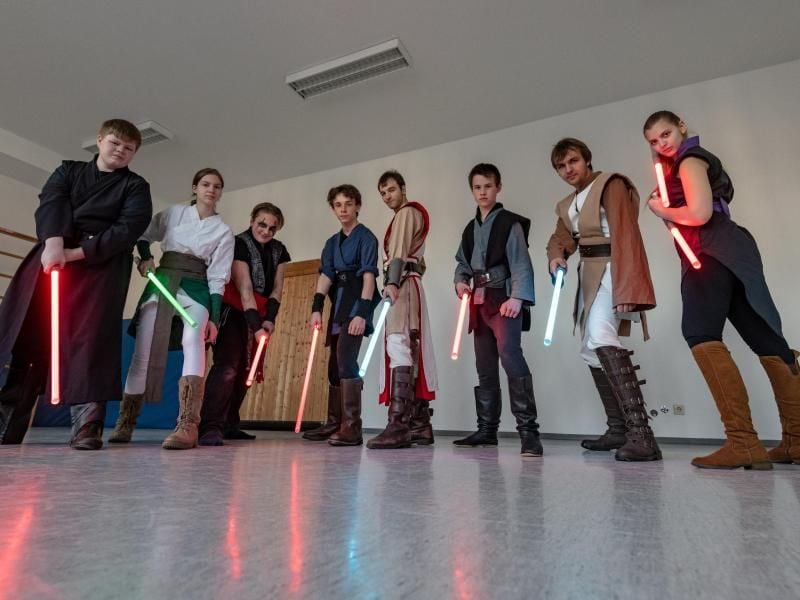 Die Mitglieder der Jedi Academy stehen mit ihren Lichtschwertern in der Turnhalle der ehemaligen Schule in Loibling. Foto: Armin Weigel