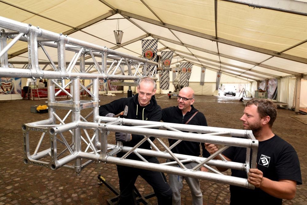 Matthias Busse (links) von der Firma Bussemusik und sein Mitarbeiter Patrick Hesse (rechts) bauen die Bühnentechnik auf. Veranstalter des Oktoberfestes ist Caruso-Chef Krisztiàn Molnàr (Mitte).