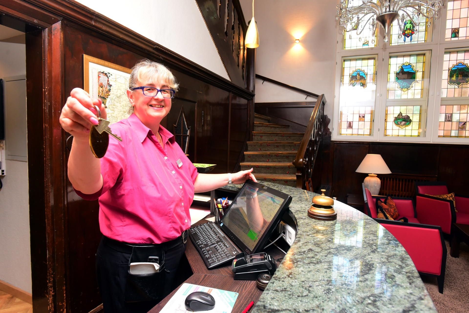 Hotelfachfrau Carmen Dreyhaupt beim überreichen des Hotelzimmerschlüssel.