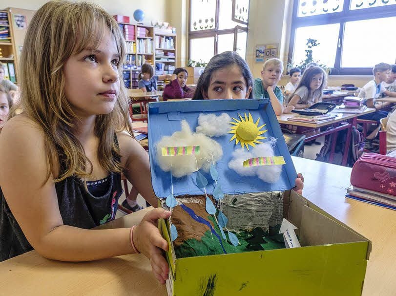Emily zeigt einen Schuhkarton, in den der Wasserkreislauf von den Jungen und Mädchen eingearbeitet wurde. Damit gewannen sie.