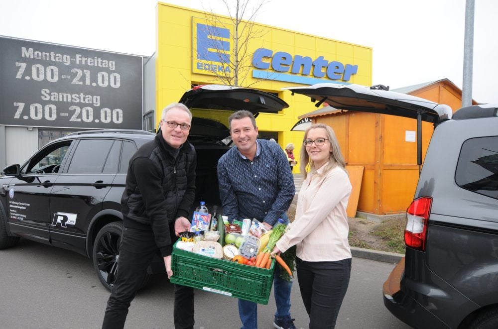 E-Center-Chef Daniel Hinze (Mitte) freut sich, dass dank Carsten Rockstroh und Katrin Jose auch Menschen an ihre Lebensmittel kommen, die in Zeiten vor Corona lieber nicht einkaufen gehen sollen.