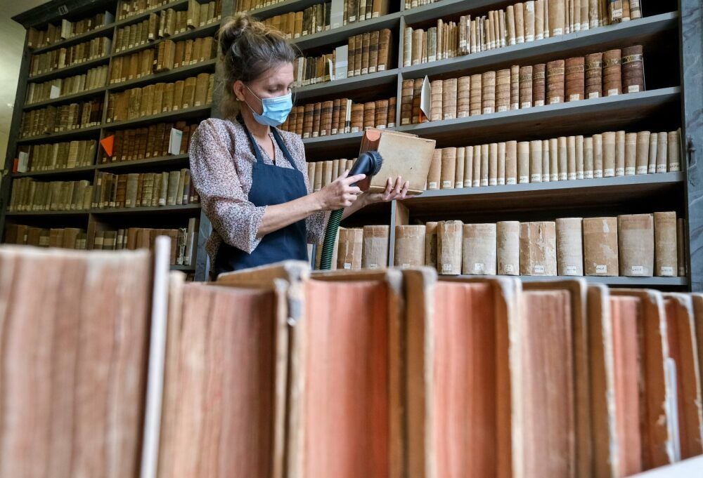 Anja Grubitzsch befreit in der Kulissenbibliothek Bücher vom Staub.