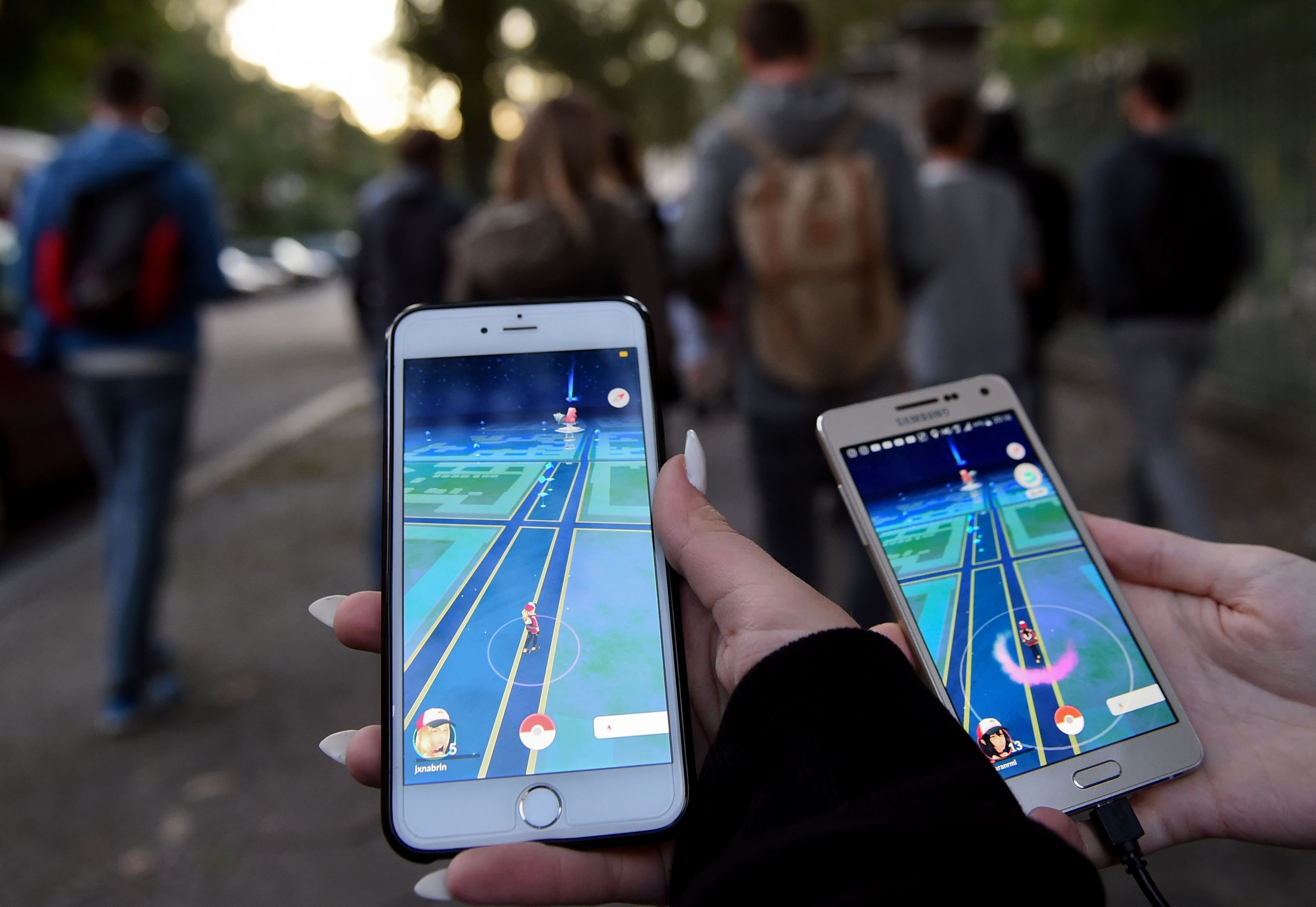Pokémonspieler gehen mit ihrem Handy durch die Straßen.
