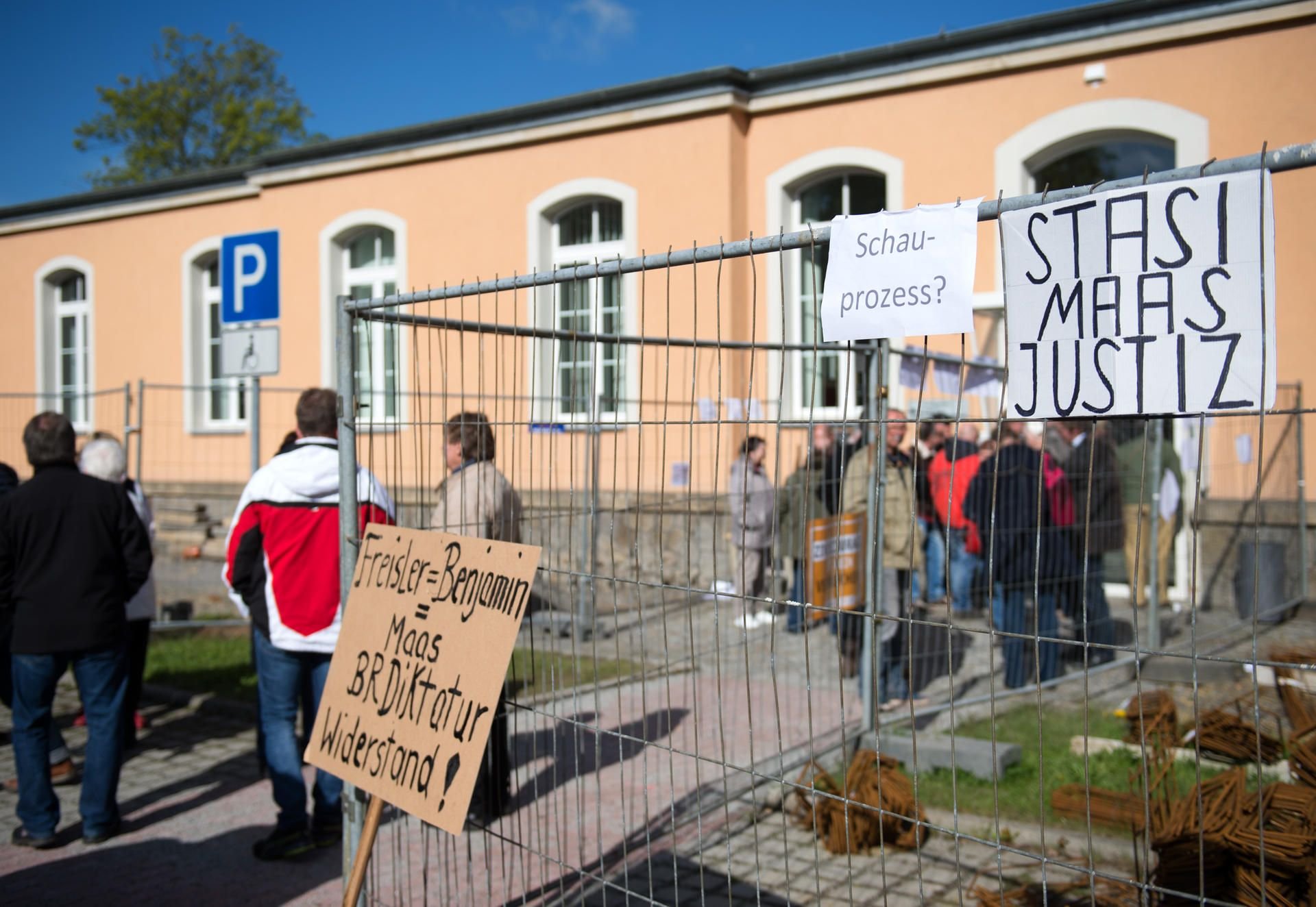 Schilder vor dem Amtsgericht in Kamenz. Knapp ein Jahr nachdem sie einen psychisch kranken Flüchtling aus einem Supermarkt gezerrt und an einen Baum gefesselt haben sollen, müssen sich die vier Männer vor Gericht verantworten.