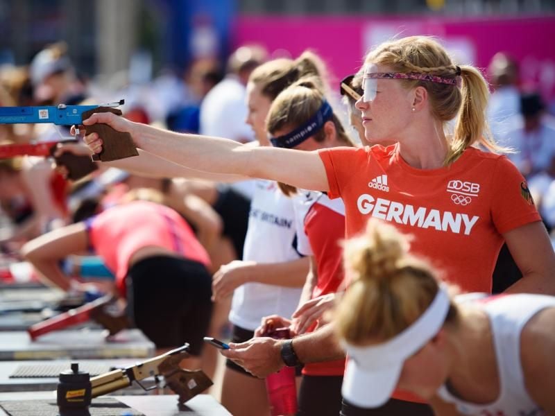 Annika Schleu zielt während der Aufwärmphase mit ihrer Laser-Pistole in der Hand auf eine Zielscheibe. Foto: Gregor Fischer