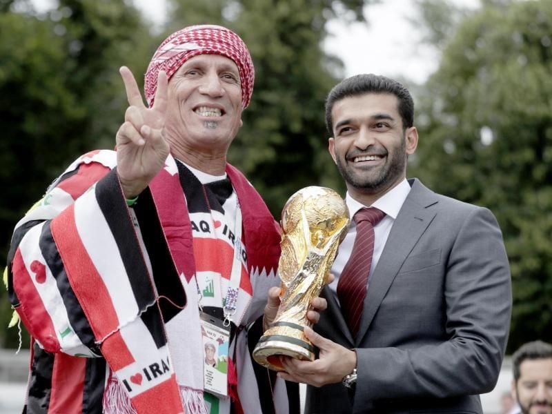 Hassan Al Thawadi (r), Generalsekretär des Organisationskomitees für die Fußball-WM 2022 in Katar, steht im Gorki-Park neben einem Fan und hält eine Abbildung des WM-Pokals. Foto: Mikhail Metzel/TASS