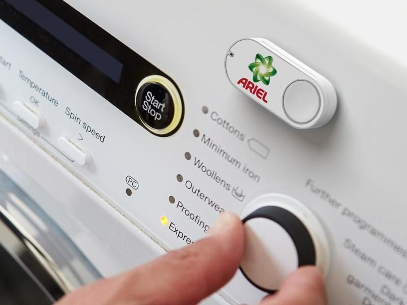 Ein Amazon Dash Button für die Marke Ariel, der an einer Waschmaschine klebt. Foto: Amazon