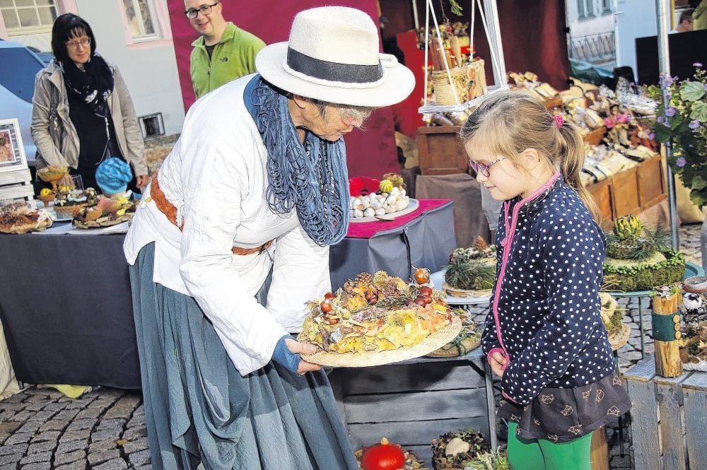 Mit ihren Natur-Gestecken wagt sich Sylvia Vogel erstmals auf den Regionalmarkt. Der kleinen Miriam (5) gefällt es.