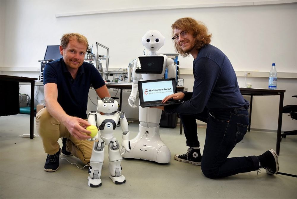Am Beispiel der beiden Roboter Nao (klein) und Pepper erforschen Stefan Twieg (li.) und Johannes Coertze, wie humanoide Roboter im Alltag der Menschen eingesetzt werden können.