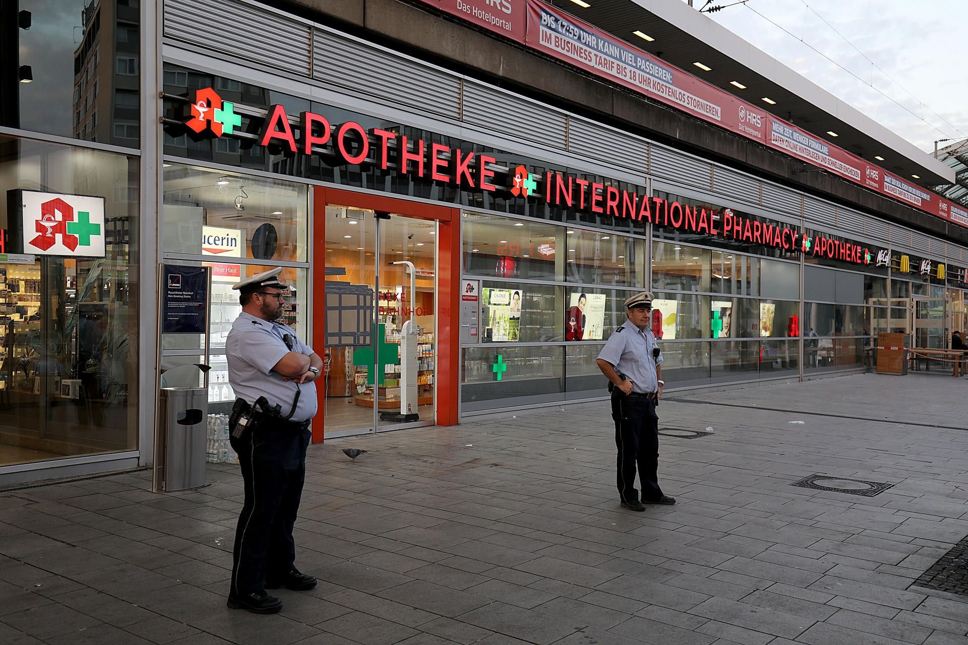 Polizisten stehen vor der Apotheke im Kölner Hauptbahnhof, in der sich der Geiselnehmer verschanzt hatte.
