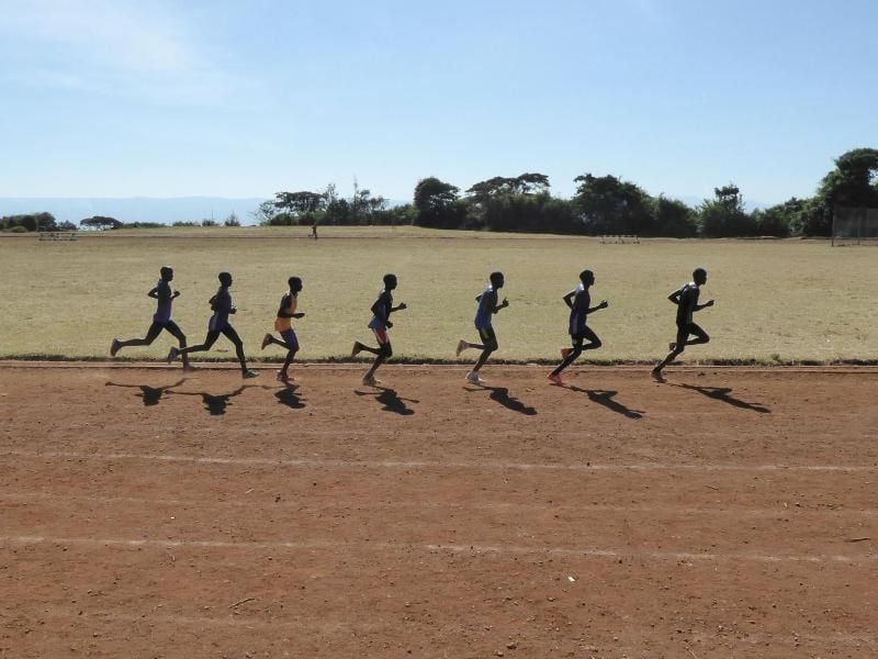 Eine Gruppe kenianischer Läufer zieht auf der Sandbahn des Sportplatzes in Iten ihre Runden. Foto: Bernd Röder/dpa