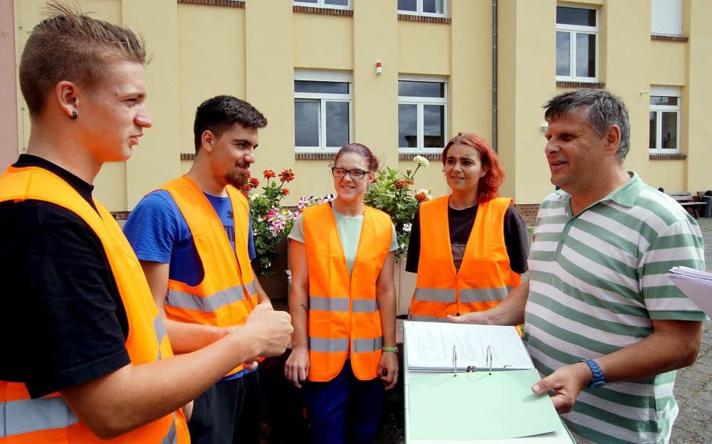 Lehrausbilder Holger Dietrich zeigt Djamila Behrendt, Cindy Koennecke, Sasha-Davut Duman und Nick Meißner (v. re.), wie die Arbeitsnachweise auszufüllen sind.