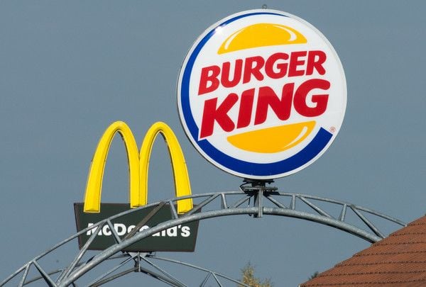 Die Logos der Fast-Food-Ketten McDonalds und Burger King auf einer Autobahnraststätte.