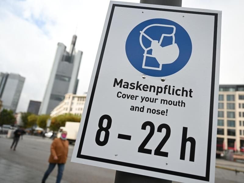 Ein Schild verweist auf der Frankfurter Einkaufsmeile Zeil auf die Maskenpflicht. Foto: Arne Dedert/dpa