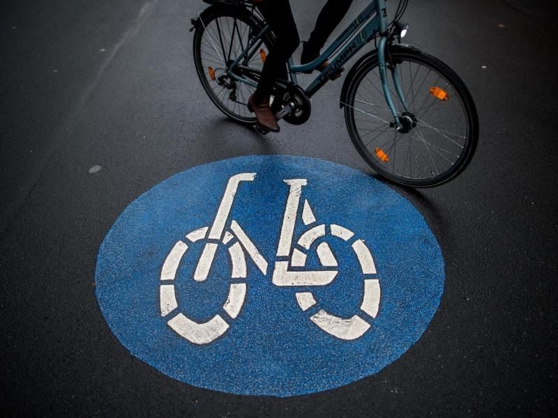 Eine Fahrradfahrerin fährt an der Fahrbahnmarkierung einer sogenannten Fahrradstraße vorbei. Foto: Hauke-Christian Dittrich/Archivbild