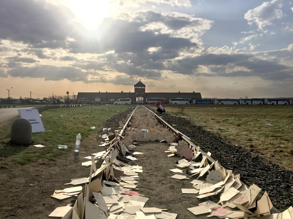 Auf den Schienen vor Birkenau liegen Karten, die an die Opfer des Holocausts erinnern
