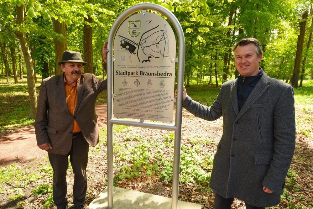 Siegfried Gallas (l.) ist für den Inhalt der neuen Tafel über den Stadtpark Braunsbedra verantwortlich. Bürgermeister Steffen Schmitz (r.) freut sich über eine weitere Attraktion auf dem Gelände.