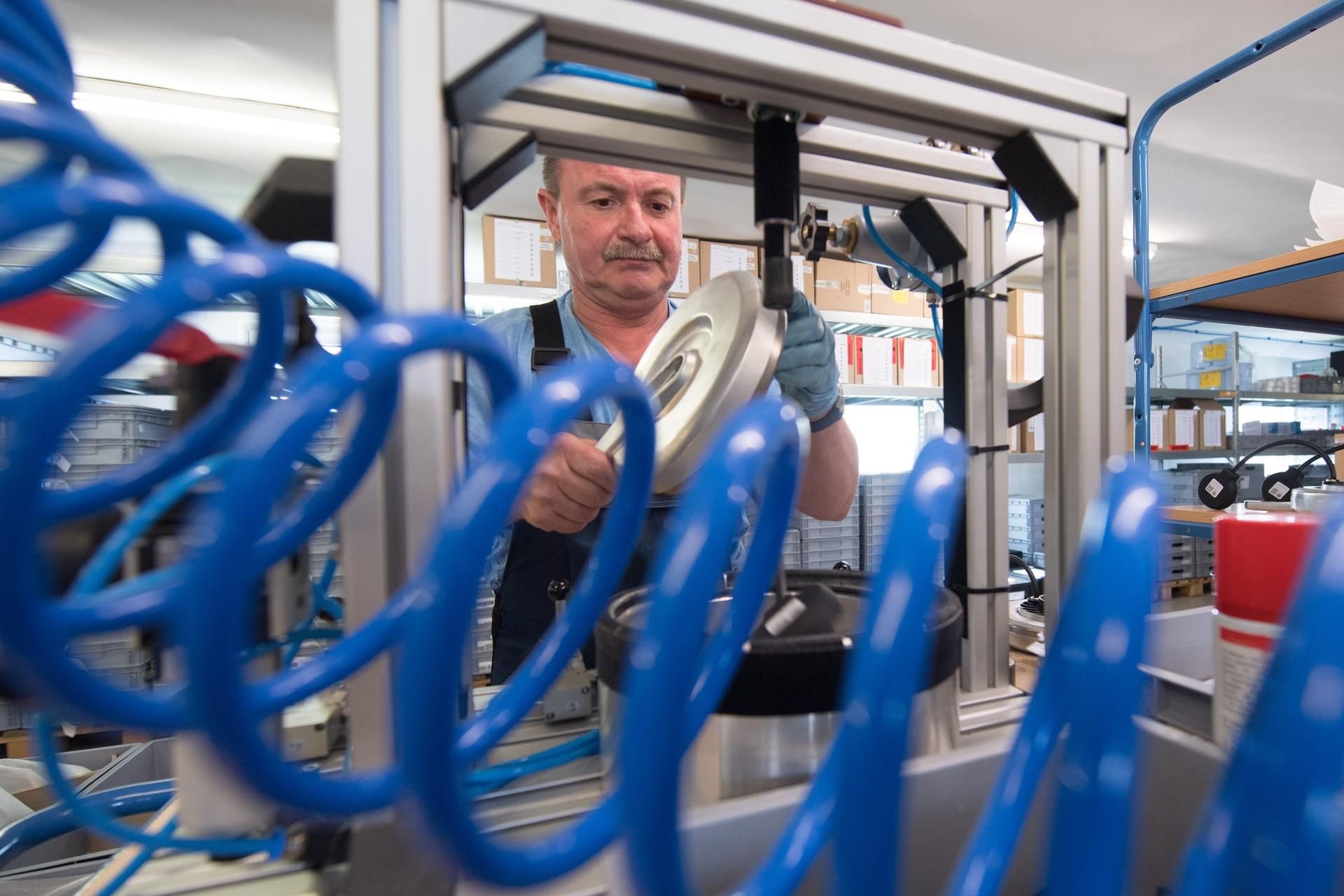 Monteur Uwe Pommer prüft in der Produktion der Pendix GmbH einen Scheibenmotor auf Dichtigkeit.