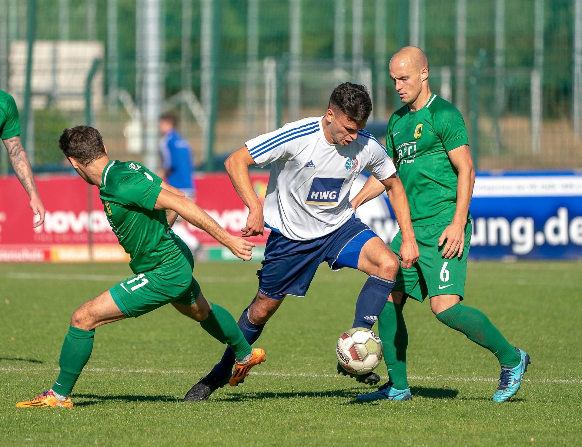Halles Tommy Kind (M.) bekommt es gleich zwei Leipziger Gegenspieler zu tun.