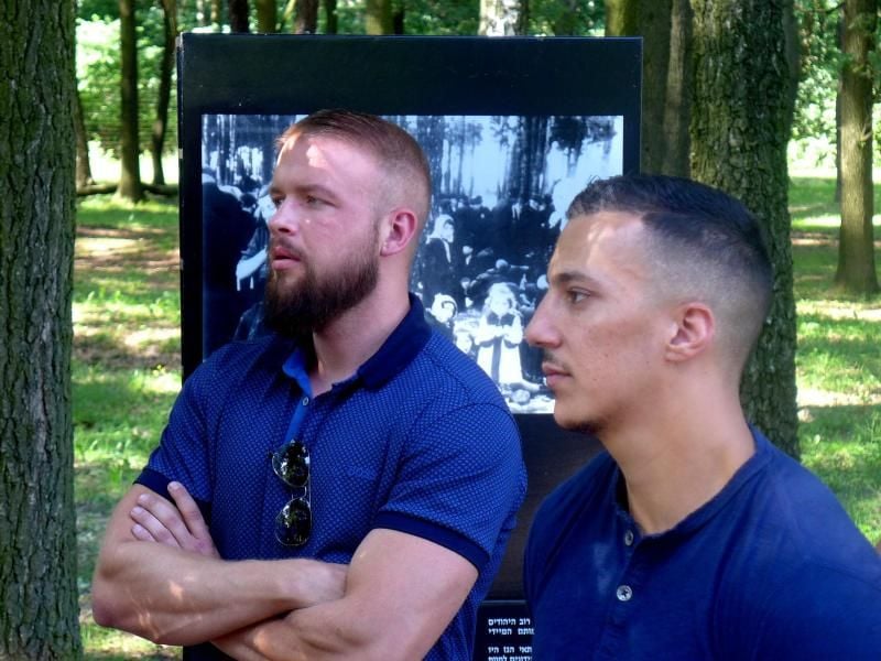 Die Rapper Kollegah (l) und Farid Bang stehen in der Nähe der Ruinen von Gaskammer und Krematorium Nummer 5 in der KZ-Gedenkstätte Auschwitz. Foto: Bernd Oertwig/Iak/Internationales Auschwitz Komitee