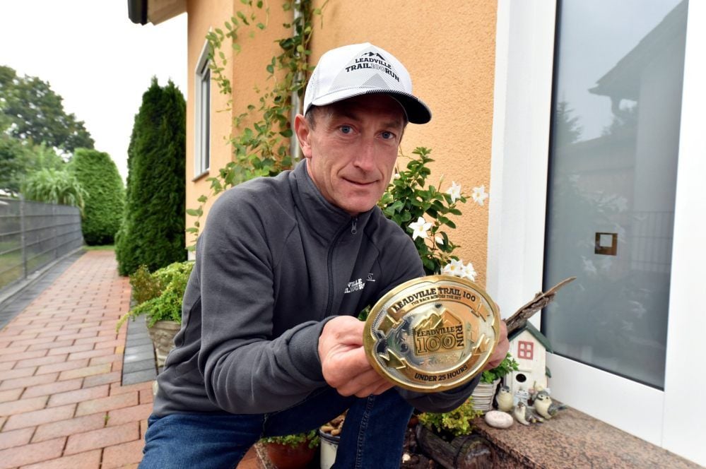 Jens Sperlich zeigt seine Gürtelschnalle, die er nach dem Rennen durch die Rocky Mountains in den USA bekommen hat.
