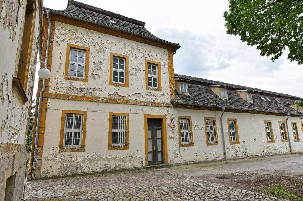 An der hinteren Fassade bröckelt der Putz.