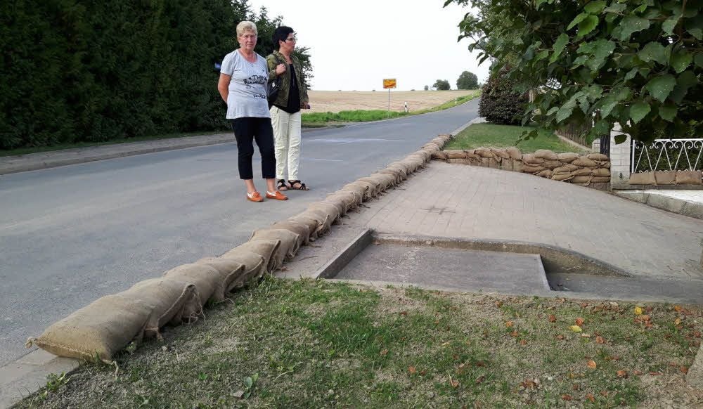 Christel Breitung (li.), hier mit Ratsmitglied Nadine Pein, kann nur hoffen, dass die Säcke im Ernstfall genug Schutz bieten. Vom oberhalb liegenden, abgeernteten Feld hatten sich Wasser und Schlamm auf die Grundstücke ergossen.