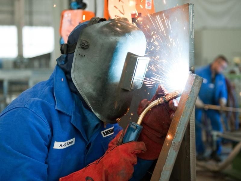 Ein Auszubildender arbeitet mit einem Schweißbrenner an einer Stahlwand. Foto: Robert Schlesinger/dpa-Zentralbild/dpa/Symbolbild