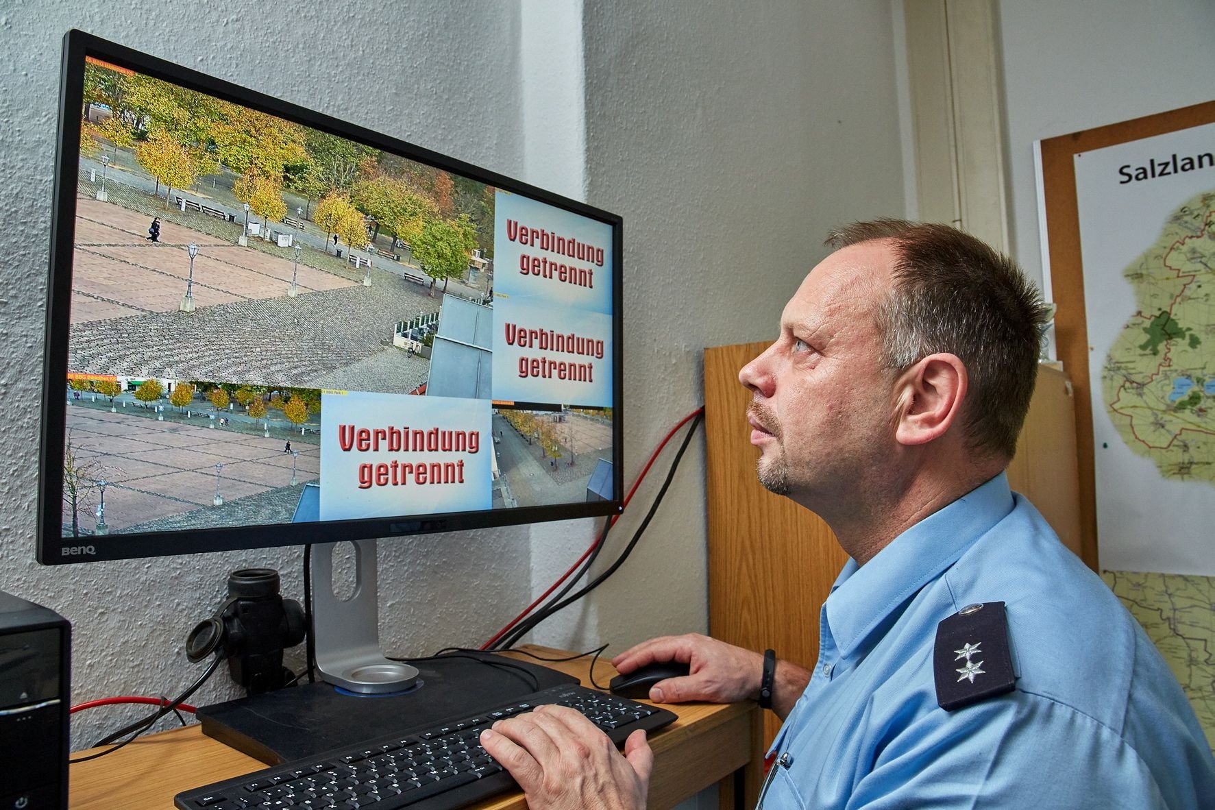 Polizeisprecher Marco Kopitz vom Revier Salzlandkreis sitzt am Bildschirm für die Überwachungskameras für den Karlsplatz in Bernburg.