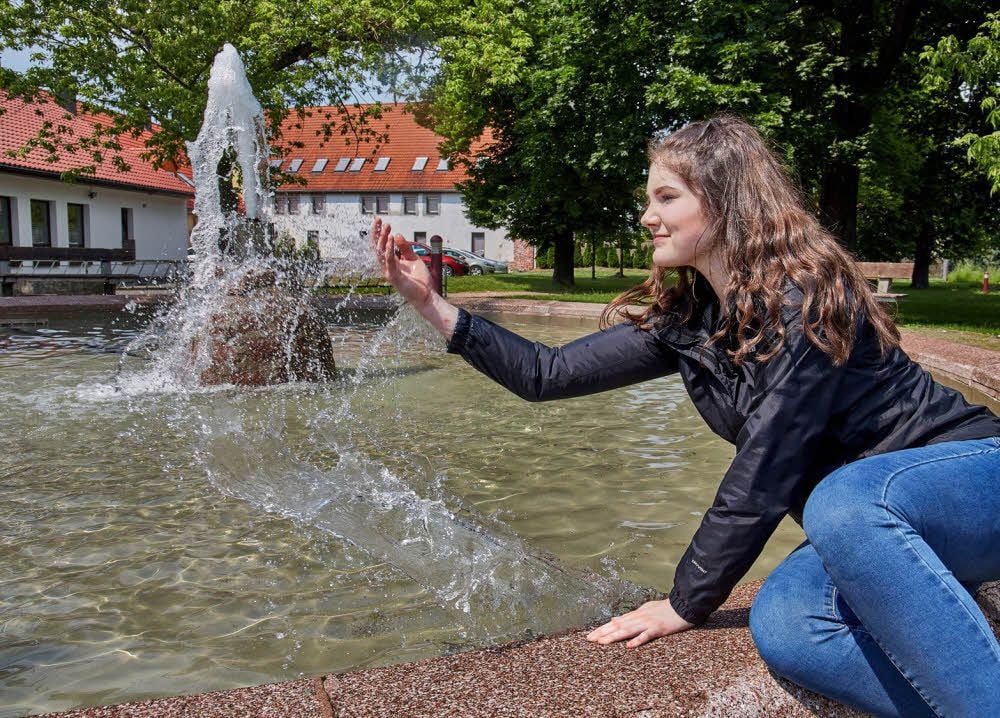 Die Könneranerin Johanna freut sich über die Wiederbelebung des Brunnens und hat schon einmal die Wassertemperatur getestet.