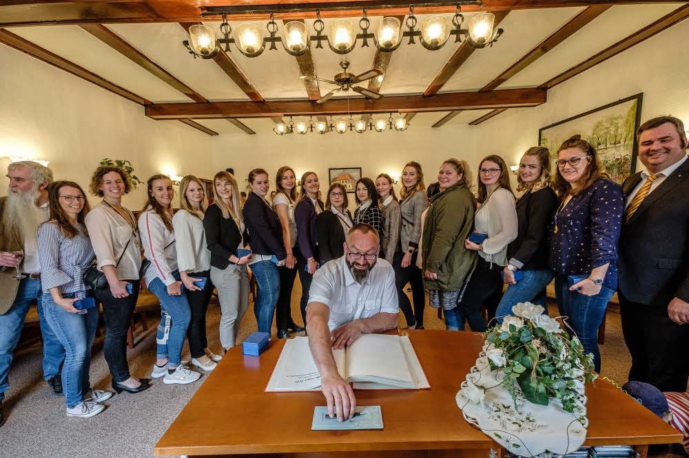 Die BSG - die Frauen haben sich in der Kleiderfrage gegen die Trikots entschieden - tragen sich ins Ehrenbuch ein. Jens Bertuleit macht den Anfang.