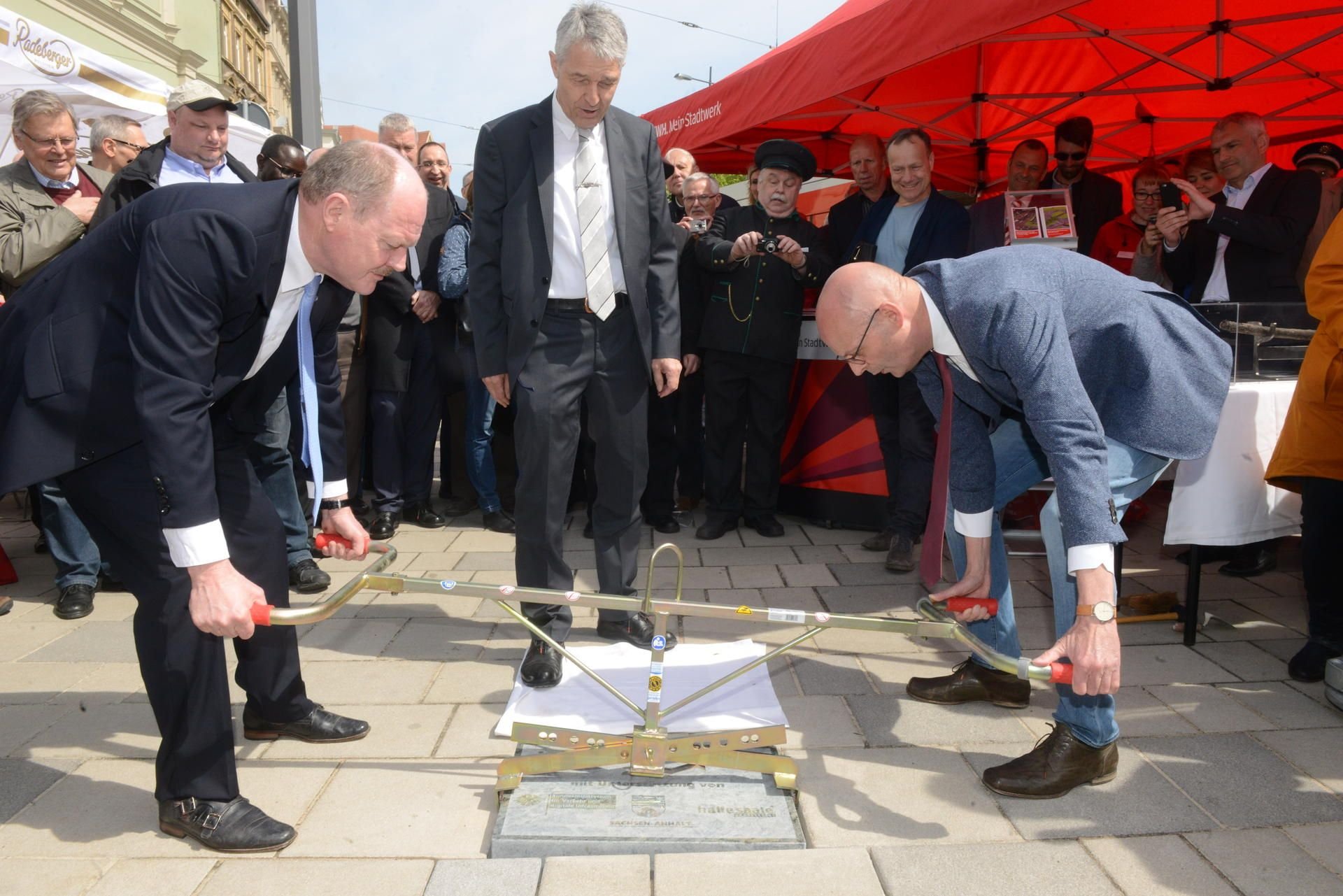Verkehrsminister Thomas Webel und Oberbürgermeister Bernd Wiegand setzen am Steintor symbolisch den letzten Pflasterstein ein.