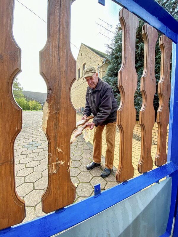 Rolf Göttert vor dem demolierten Hoftor. In der Hand hält er die zerstörten Bretter.