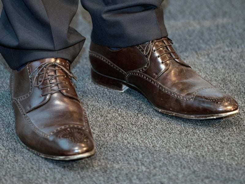 So geht's. Dunkelbraune Schuhe passen zum schwarzen Anzug. Foto: Boris Roessler/dpa
