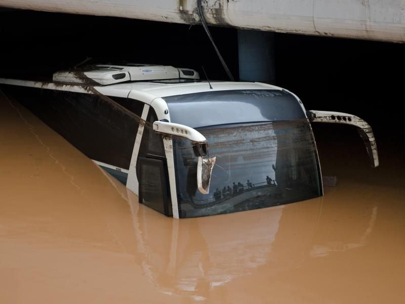 Ein Bus steht unter einer Autobahnbrücke in Athen bis zum Dach im Wasser. Foto: Petros Giannakouris