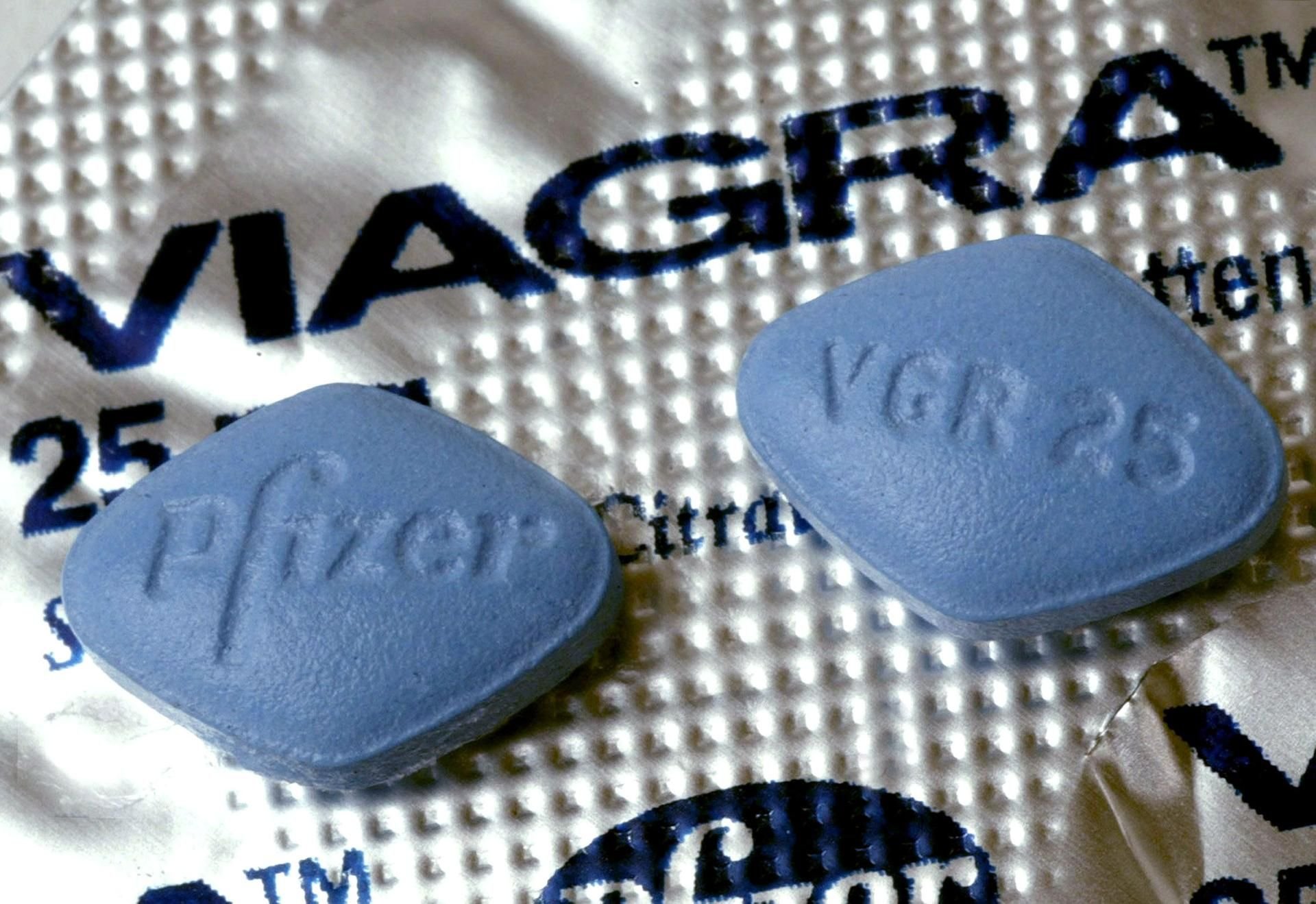 Zwei Tabletten Viagra liegen auf der Medikamentenverpackung.