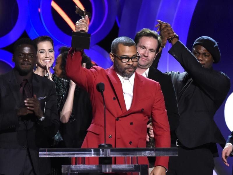 Jordan Peele (M) erhält die Trophäen für besten Film und Regie für „Get Out” bei der Verleihung der Independent Spirit Awards. Foto: Chris Pizzello/Invision/AP